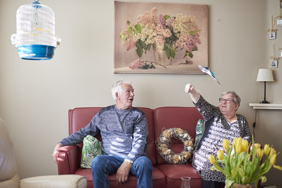 Man en vrouw zittend op de bank met een vogel