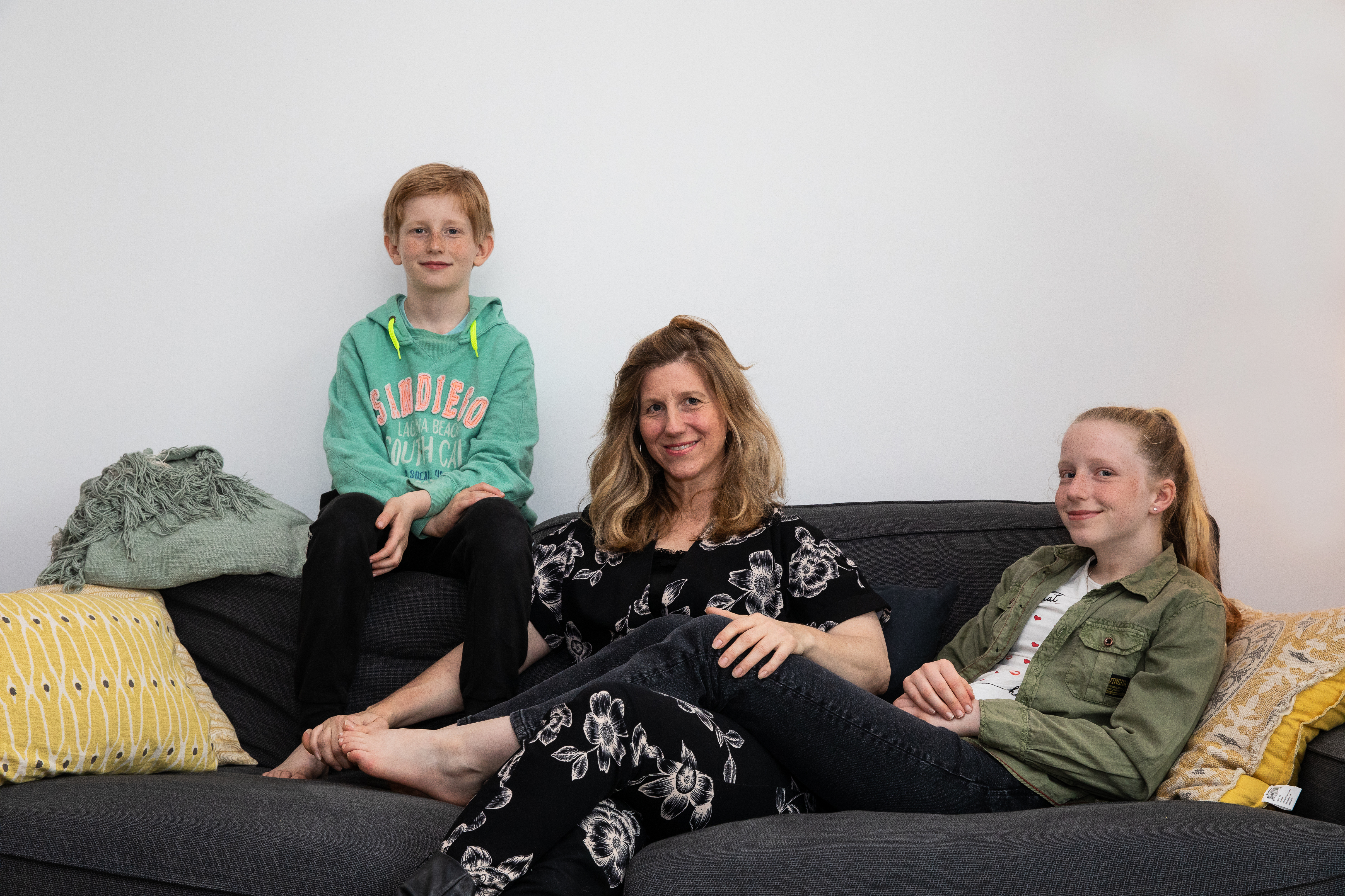 Vrouw met twee kinderen op de bank